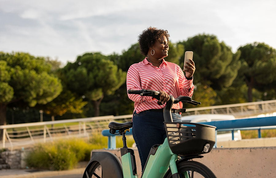 Image woman viewing mobile phone with a bike